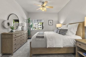 The master bedroom in a new home with a bed and dresser